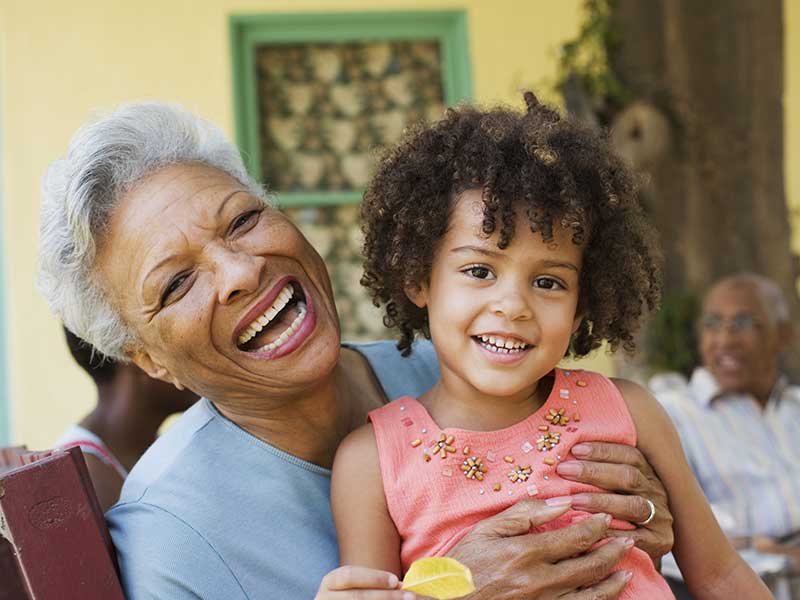 Woman and young girl outdoors with people in background Our Philosophy